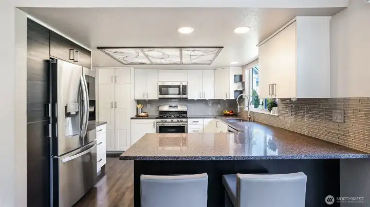 sleek stainless steel, stylish cabinetry, and island seating blend design with comfort.