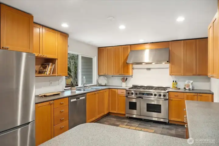 Chef’s kitchen boasts professional-grade sparkling stainless steel appliances. Check out that stovetop and hood! A home chef's dream and delight!