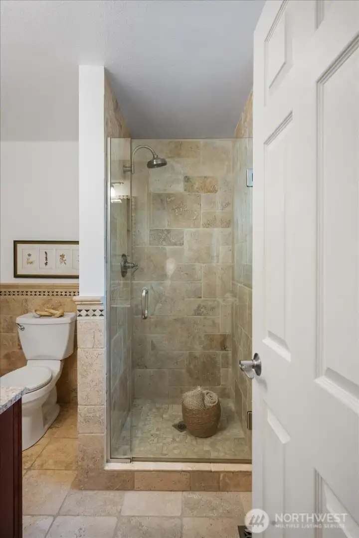 Spa inspired en-suite primary bath featuring beautiful tiling, glass enclosure!