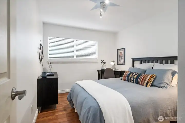 Beautiful guest bedroom that is showered with natural light, and gorgeous flooring!