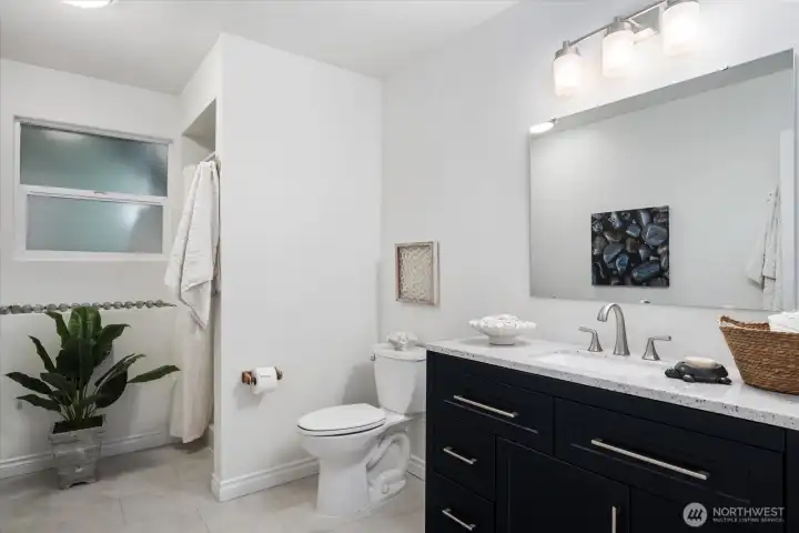 Newly updated lower-level bath has beautiful modern touches with new custom vanity and LVP tile flooring! This bathroom has a calm and serene feel! So hard to get 3 showers in a home, so this is awesome amenity!