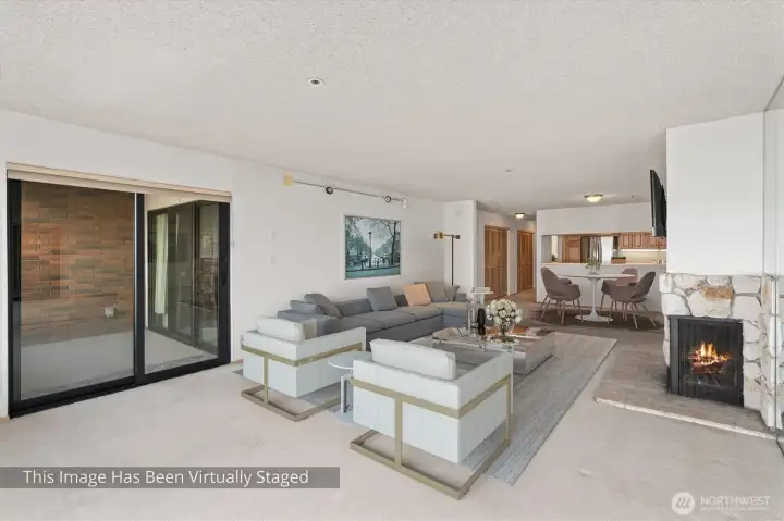 In this photograph, the sliding glass door on the left opens onto the view deck, offering an inviting transition to the outdoor space. To the right, the interior flows seamlessly into the dining area and kitchen, creating a cohesive and functional living environment.