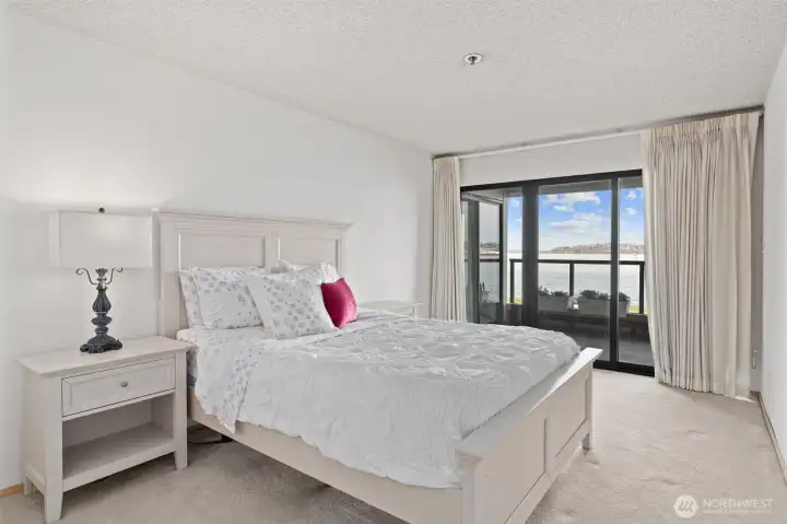 The primary suite features a spacious sliding glass door that seamlessly opens onto the view deck, creating an inviting space to enjoy your morning coffee while basking in the sunrise or to unwind with a refreshing evening beverage as the sun sets.