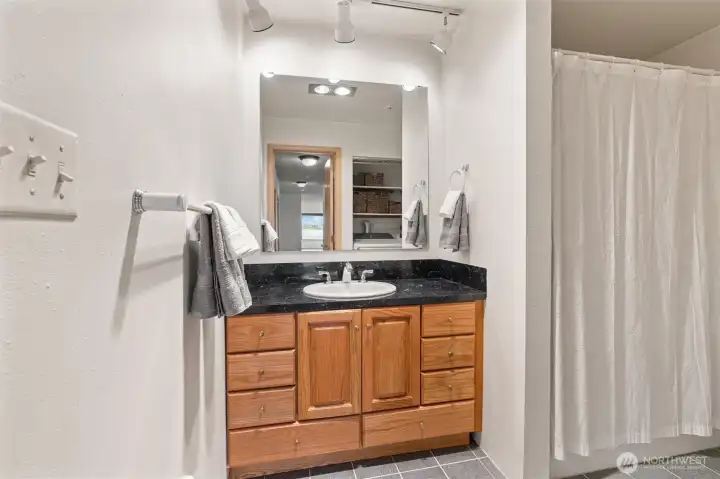 The guest bathroom conveniently includes a full-sized washer and dryer, both just one year old, providing modern functionality without compromising space or style.