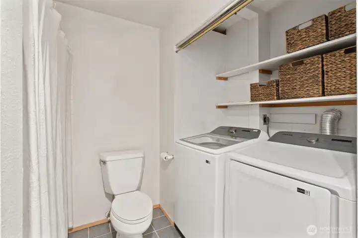 The guest bathroom conveniently includes a full-sized washer and dryer, both just one year old, providing modern functionality without compromising space or style.