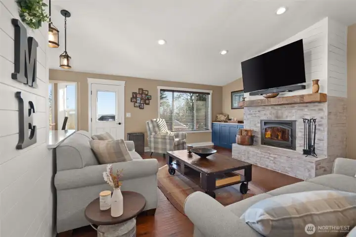 Living Room with wood burning fireplace with a brick surround.