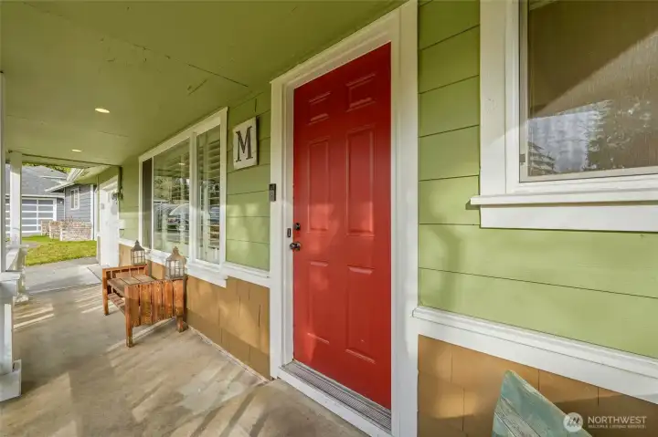 A covered front patio welcomes you to an inviting front door.