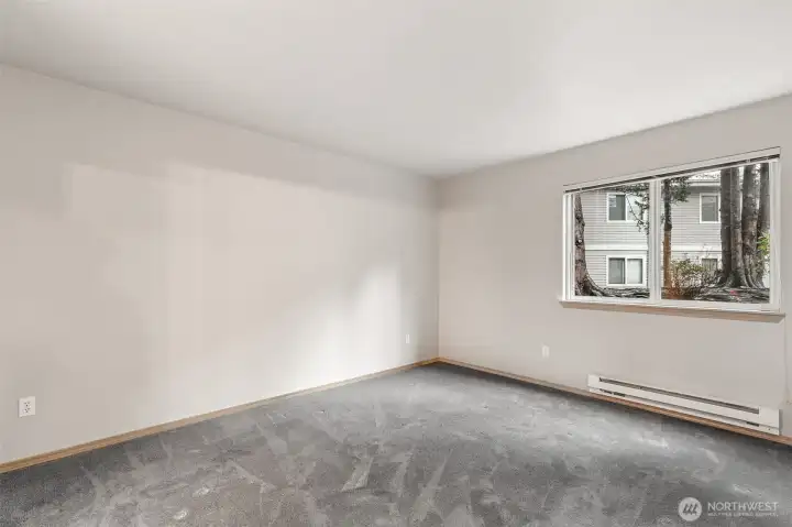 Primary Bedroom with Natural Light & View of Landscape between Buildings