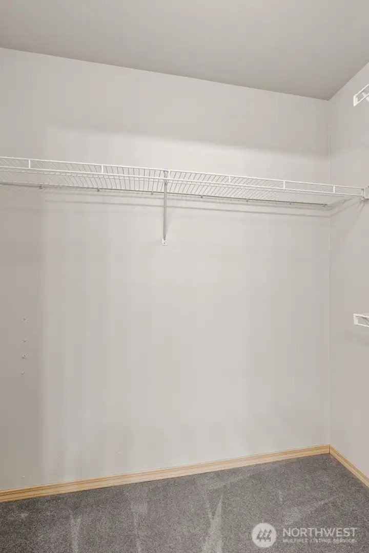 Primary Ensuite Walk-In Closet with Shelves on 3 Walls & Large Open Doorway
