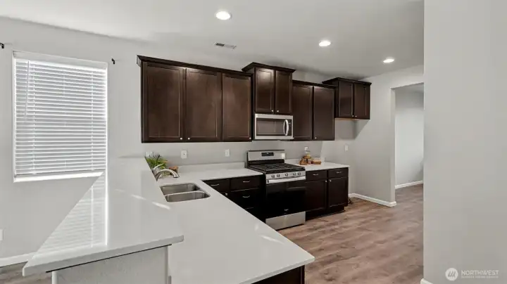 A true chef’s paradise showcasing beautiful quartz countertops, stainless steel appliances, and a highly functional design.