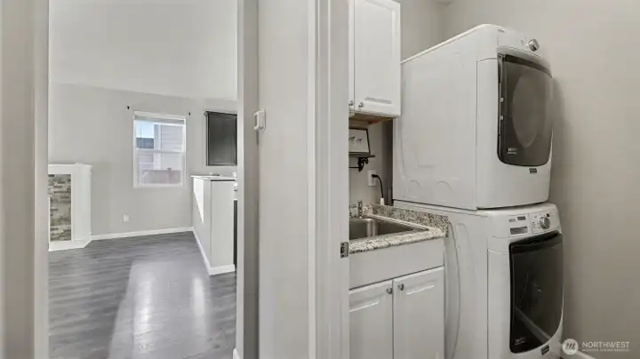 Convenient laundry room with utility sink; washer and dryer included for added ease and functionality.