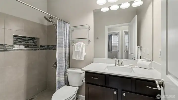 Guest bathroom features custom oversized tile shower with no threshold for easy wheelchair access.