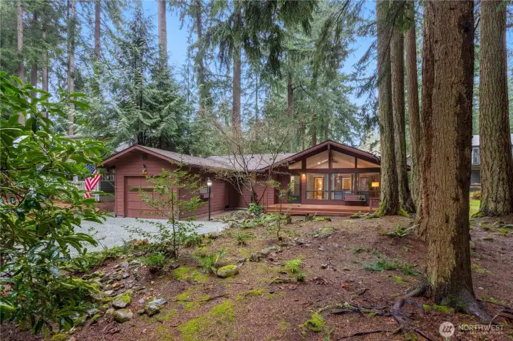 Tucked among mature evergreens, this home offers a peaceful, private setting.