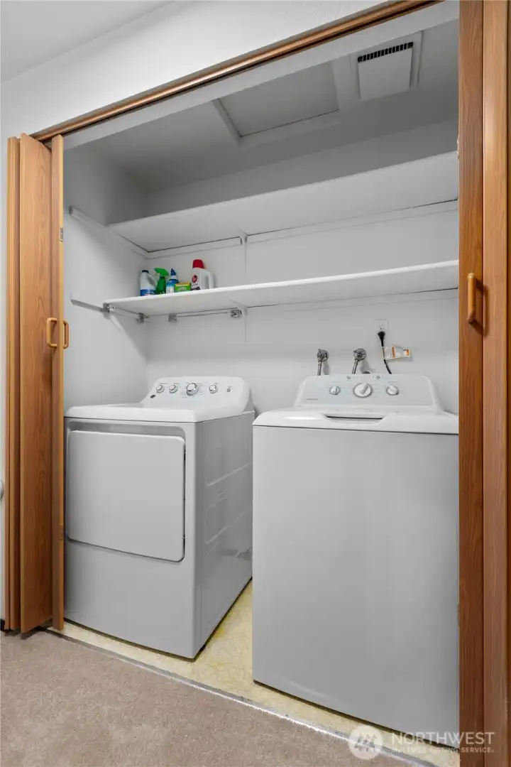 Dedicated laundry area with additional storage space.