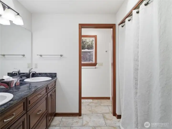 PRIMARY BATH - Granite Counter w Double Sinks. Private Shower & Toilet Rm beyond. LAUNDRY to the right.