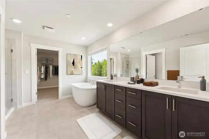 Primary bath with spacious walk-in closet + adjoining laundry room. Virtually staged.