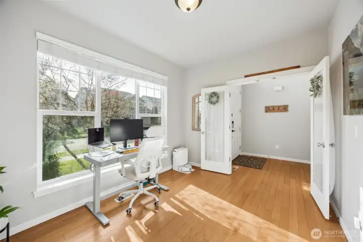 Main floor office with bright light, hardwood floors & French doors for privacy.