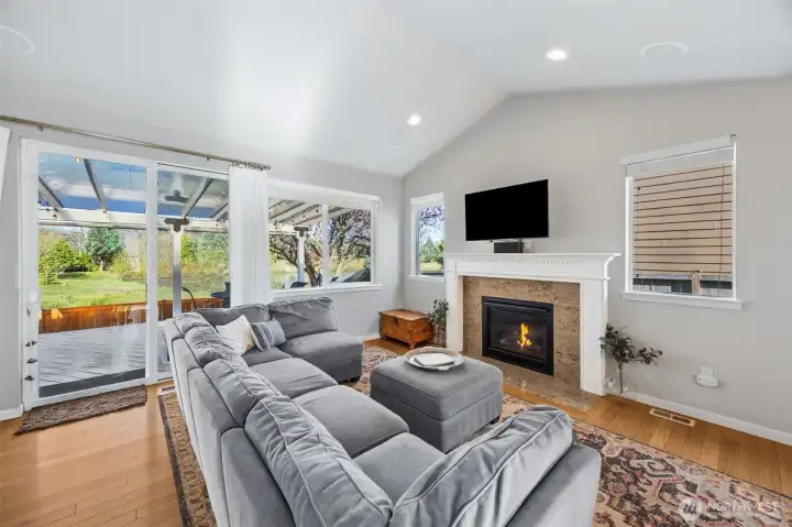 Vaulted ceilings, hardwood floors, gas fireplace and sliding glass door leads to back covered deck- perfect place for entertaining or just being cozy at night.