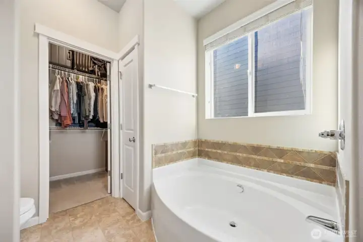 Primary bathroom - oversized soaking tub & organized walk-in closet.