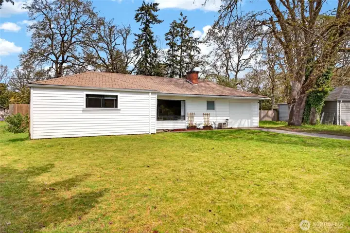 Large front yard view of home with easy vinyl siding lots of mature landscaping and more room to landscape and play in front yard