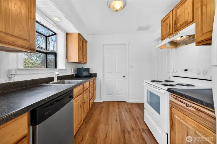Nicely updated kitchen with new cabinets, new appliances and lots of room to cook.  Door leads to laundry and garage