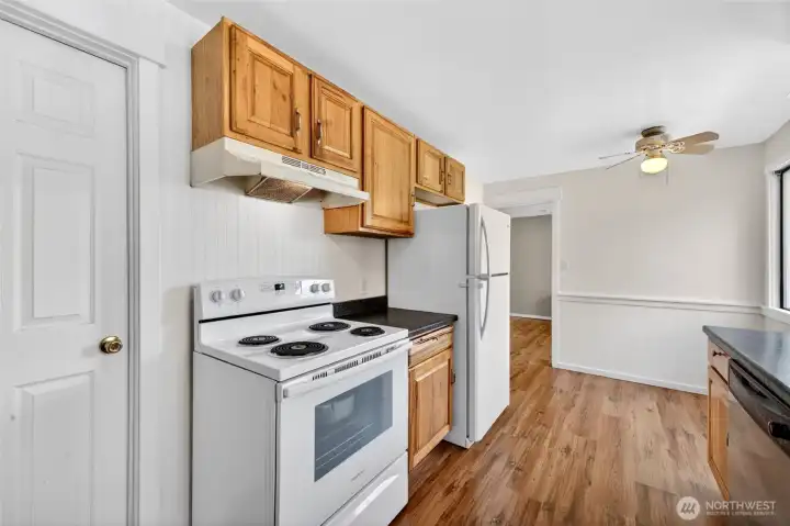 View of pass through updated kitchen with door leading to laundry.  There is lots of storage and cabinets for your cooking needs