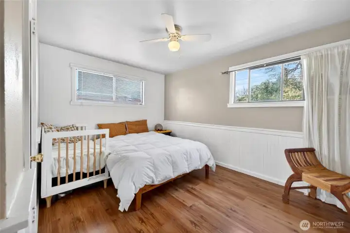 Bedroom 1 with wainscotting light colors and lots of windows