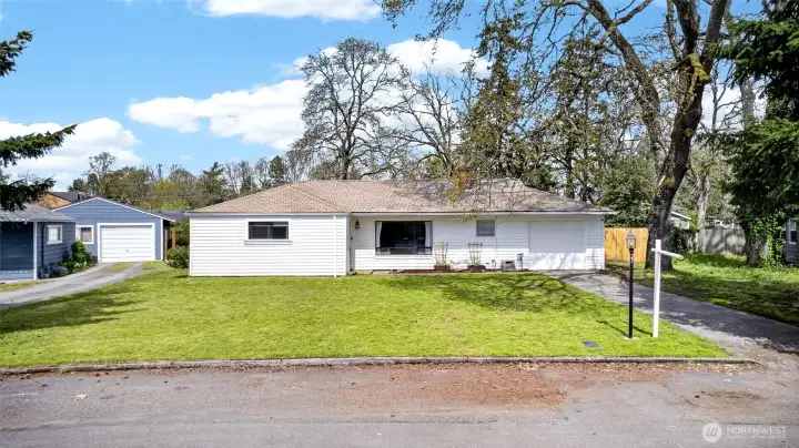 Street view of one level home with 1 car garage and lots of parking