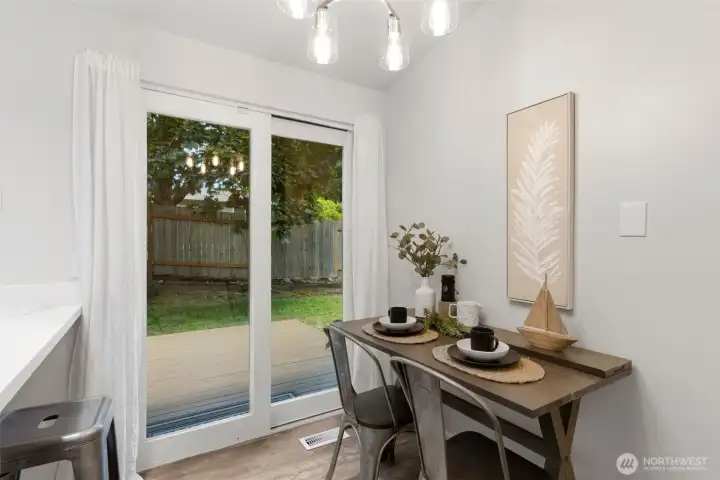 The kitchen with eating space leads to the backyard.