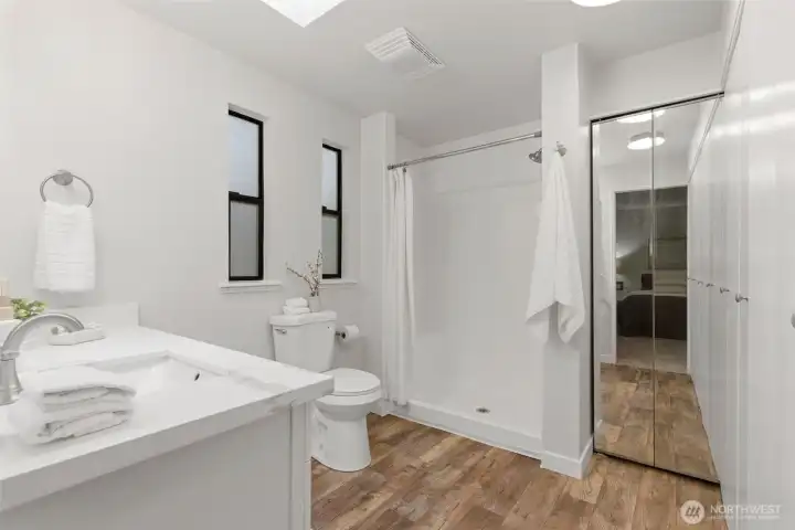 Primary bathroom featuring a walk-in shower and plenty of storage space.