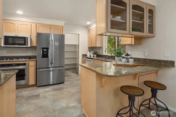 Spacious kitchen with large pantry, ample counter space and cabinets for storage.