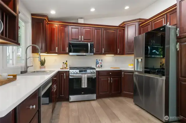 The well-appointed kitchen is equipped with new LG Smart appliances, ample cabinets and quartz countertops