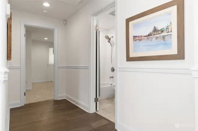 Wide hallway separates primary suite from secondary bedrooms, creating a feeling of privacy