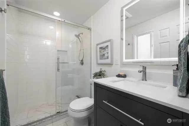 Remodeled 3/4 bath off primary suite, offers a luxurious tiled walk-in shower