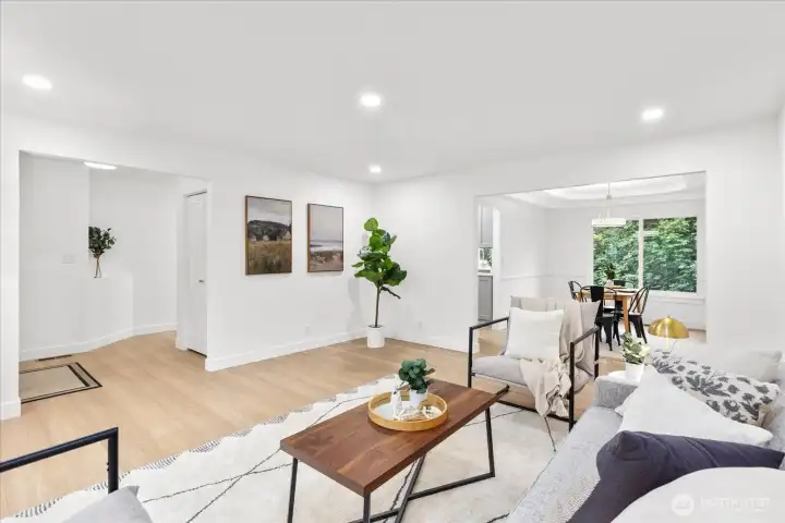 Enter to the main living area, featuring luxury vinyl plank flooring, fresh paint, craftsman trim, and adjustable canless lighting. Adjoining formal dining room with tray ceiling and chair rail molding.