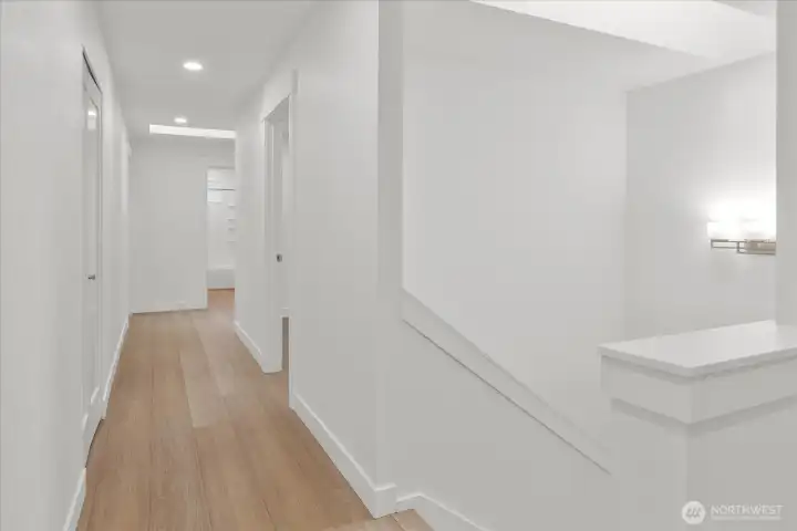 Upstairs hallway. Luxury vinyl plank flooring, fresh paint, solid wood, single-panel white shaker doors with full wood craftsman bungalow casing craftsman trim, and adjustable canless lighting throughout the home.