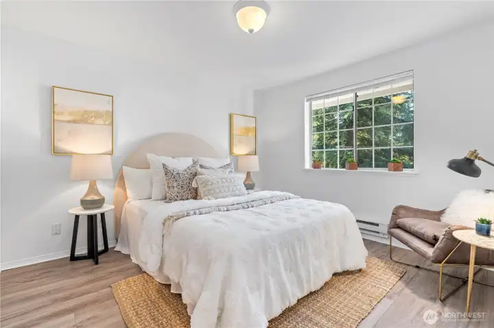 Generous primary bedroom with updated engineered hardwood flooring, en-suite full bathroom and walk-in closet.