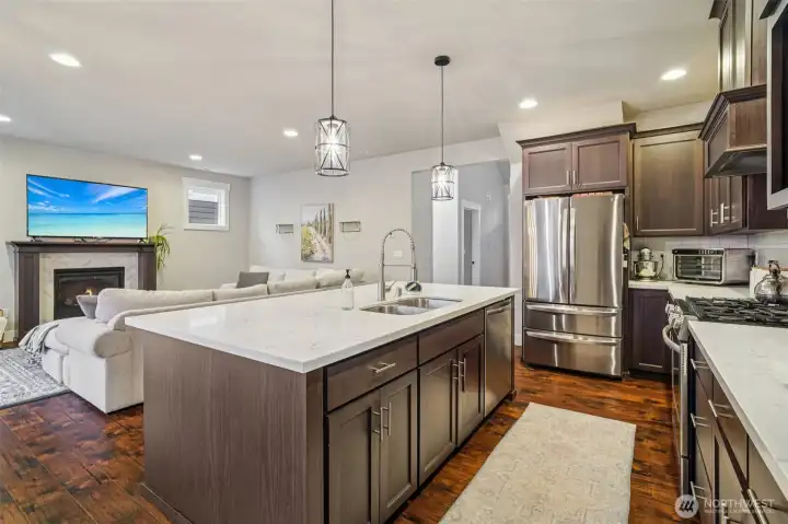 Open kitchen with quartz countertops, large island, and stainless appliances