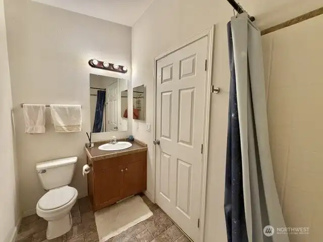 Continental bath with access to laundry/ side door and hallway near bedrooms