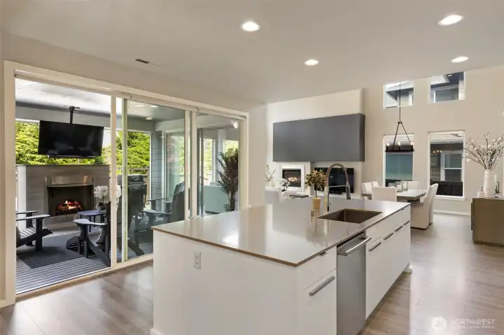 Outdoor living with fireplace and television off of kitchen