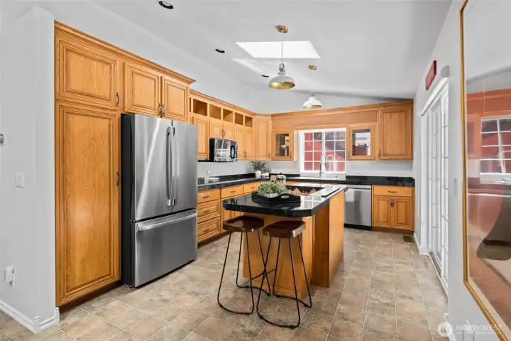 Lots of counter space with abundant light from sliding glass doors and sky light. Note: Vaulted Ceiling.