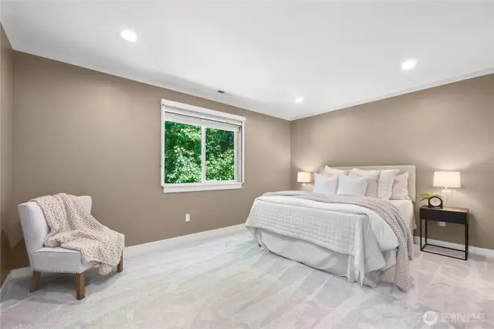 Large and roomy primary suite with crown molding, new carpet and a view to the lush greenery behind the house. Large and roomy primary suite with crown molding, new carpet and a view to the lush greenery behind the house.