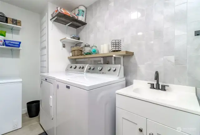 Adjacent to the kitchen sits the laundry/utility room, neat and tidy with bonus vanity sink.