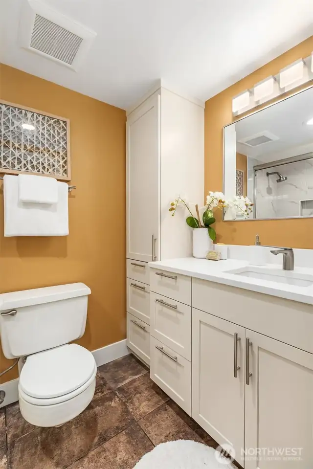 Full bath with stone tile flooring.