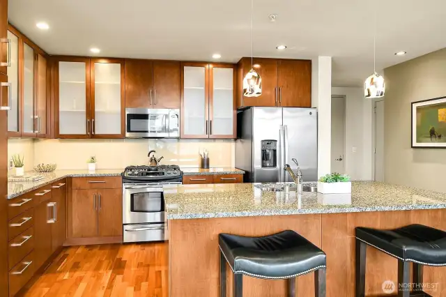 Granite/stainless kitchen with island (including a breakfast bar).