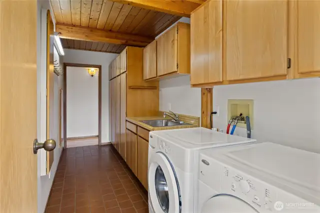 The main floor laundry room includes a utility sink and abundant storage space.