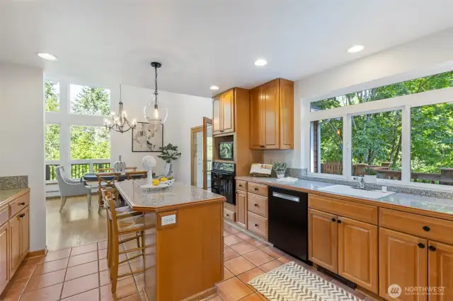 Stunning kitchen features solid maple cabinets, granite counters, breakfast bar, and oodles of storage.