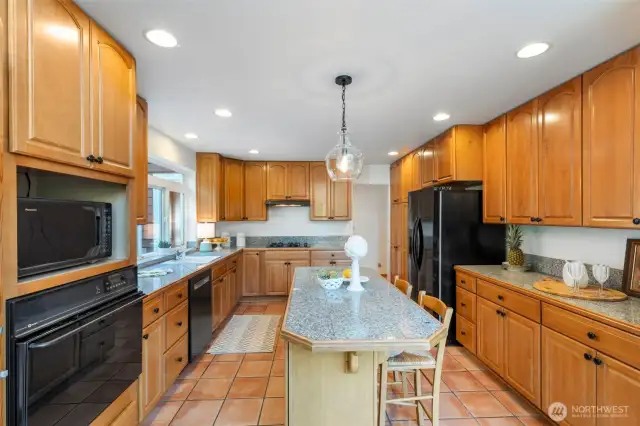 Stunning kitchen features solid maple cabinets, granite counters, breakfast bar, and oodles of storage.