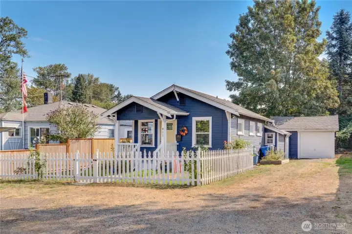 With its classic white picket fence and storybook charm, this picturesque cottage feels like home from the very first glance. It invites you in with garden beds and a newly painted front door that pops with personality.