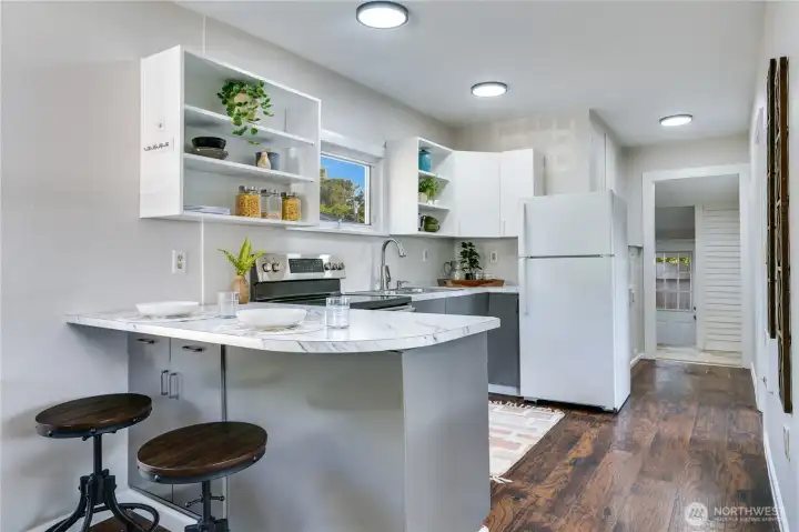 Bright, fresh, and open—this kitchen features newly painted cabinets, a sunny window over the sink, and a bar that’s perfect for quick bites or catching up with friends.